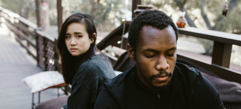 Two people sitting back-to-back.
