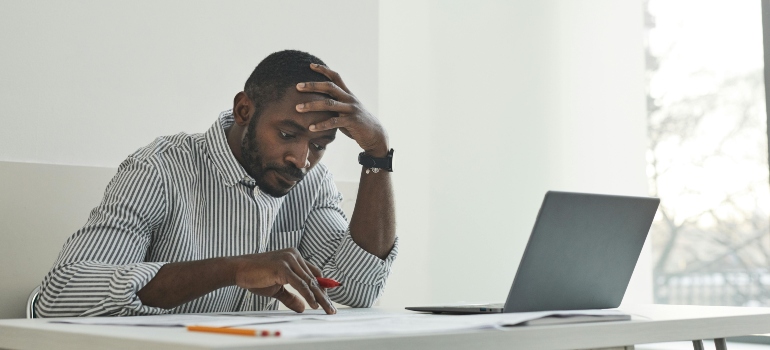 A person sitting at a desk with a confused expression, struggling with dangers of long-term Valium use.