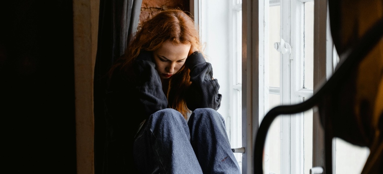 A person sitting alone, looking anxious.